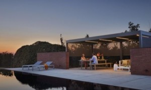 A couple enjoying their pool house at sunset.