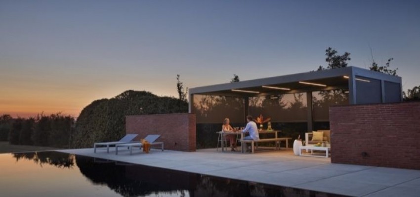 A couple enjoying their pool house at sunset.