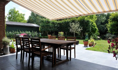 Brustor Garden Awning installed over a patio with dining table and chairs