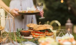 Woman enjoying food at a garden party. 