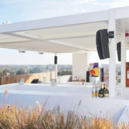 A white metal pergola being used as a beautiful garden bar. 